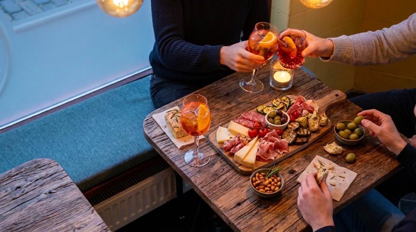 Aperitivo bij Sosta in de avond: Aperol Spritz, een tagliere, olijven en noten